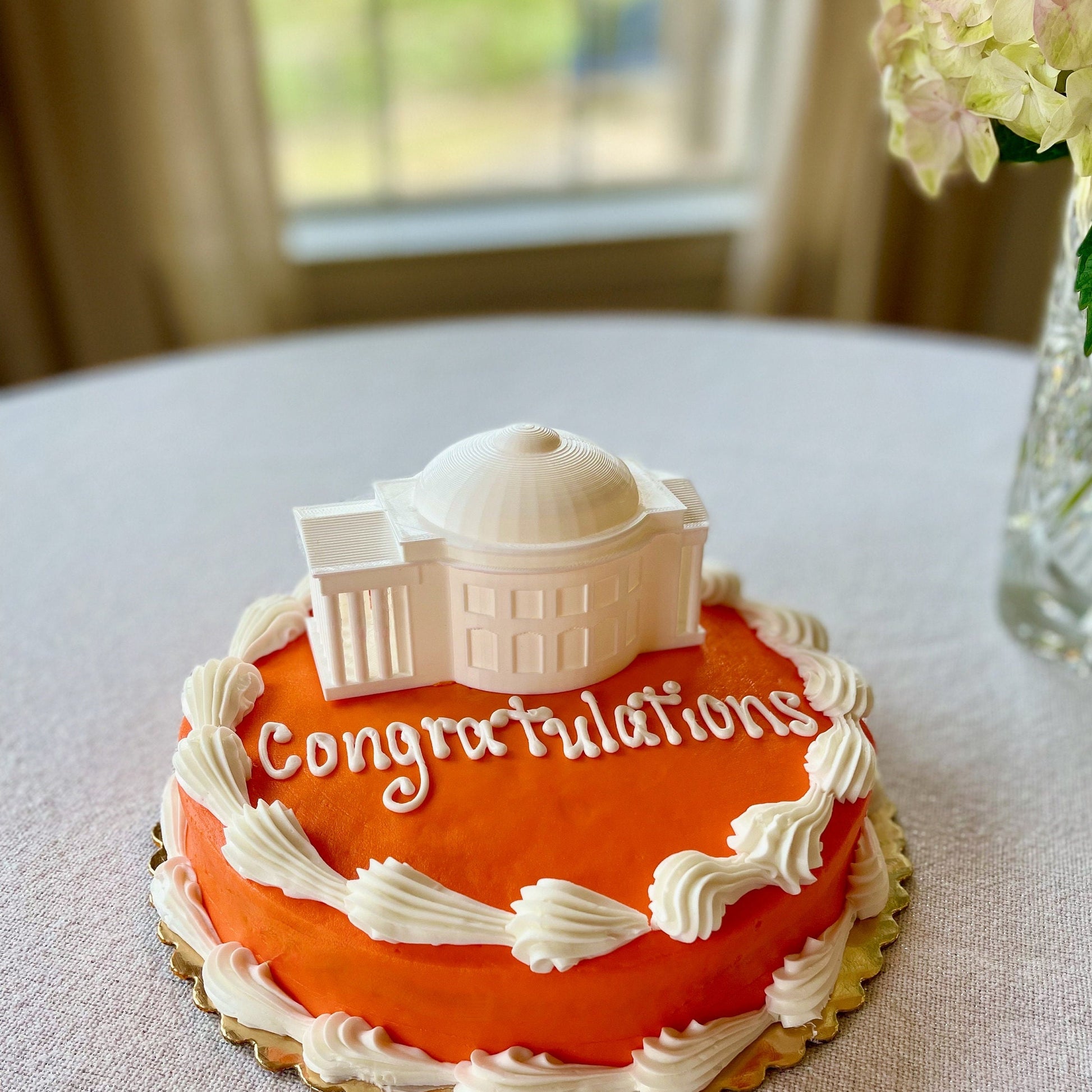 The lighted UVA cake topper, shown on an orange UVA graduation cake.