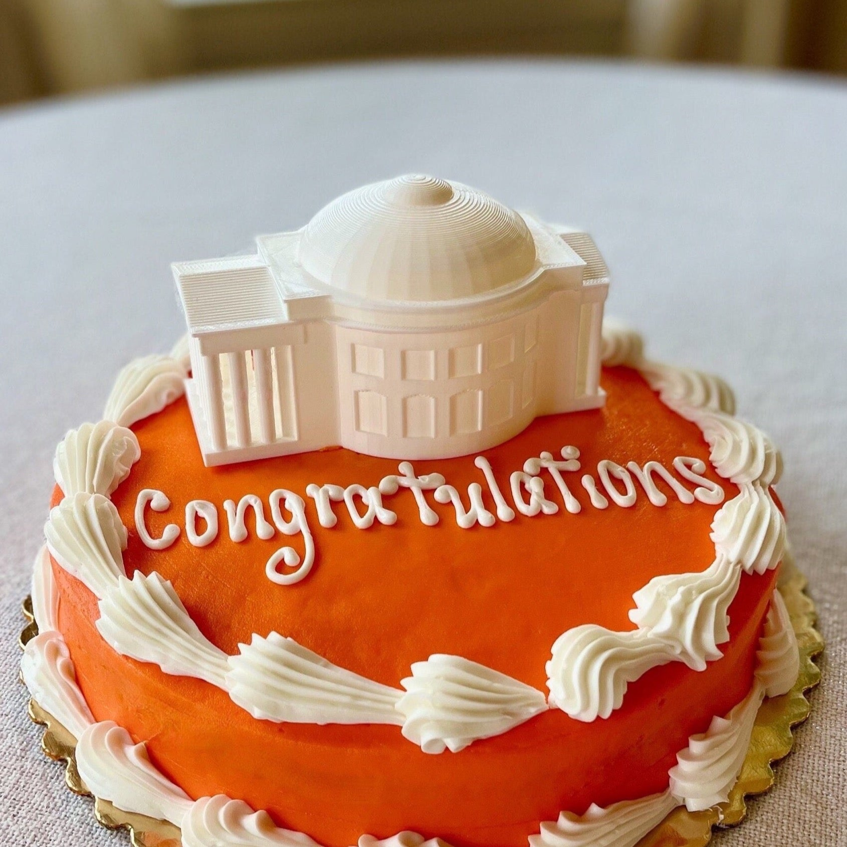 The lighted UVA cake topper, shown on an orange UVA graduation cake.