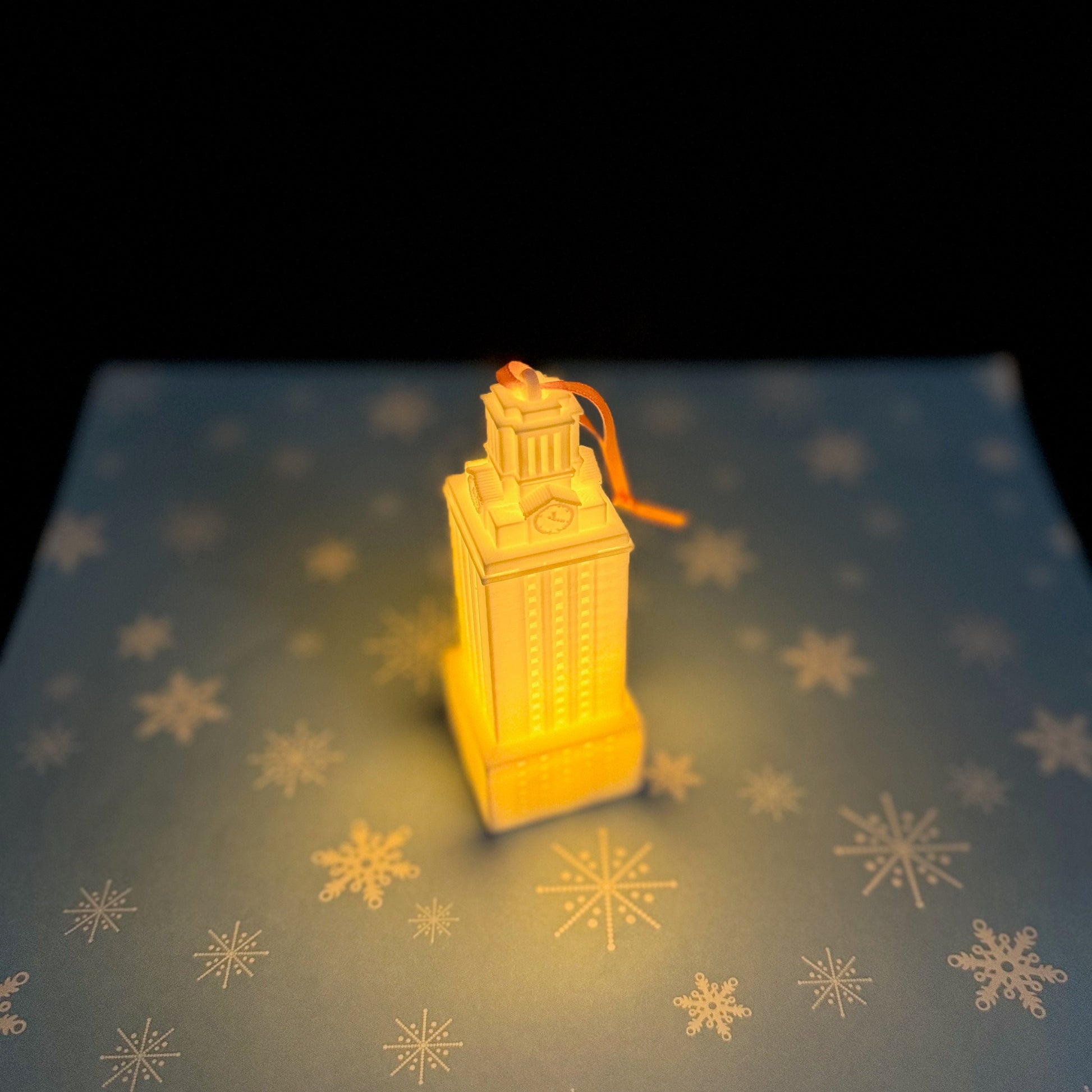 The lighted ornament for the University of Texas, shown lit in a dark room.