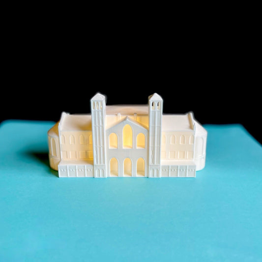 The lighted UCLA figurine of Royce Hall, shown against a blue background.