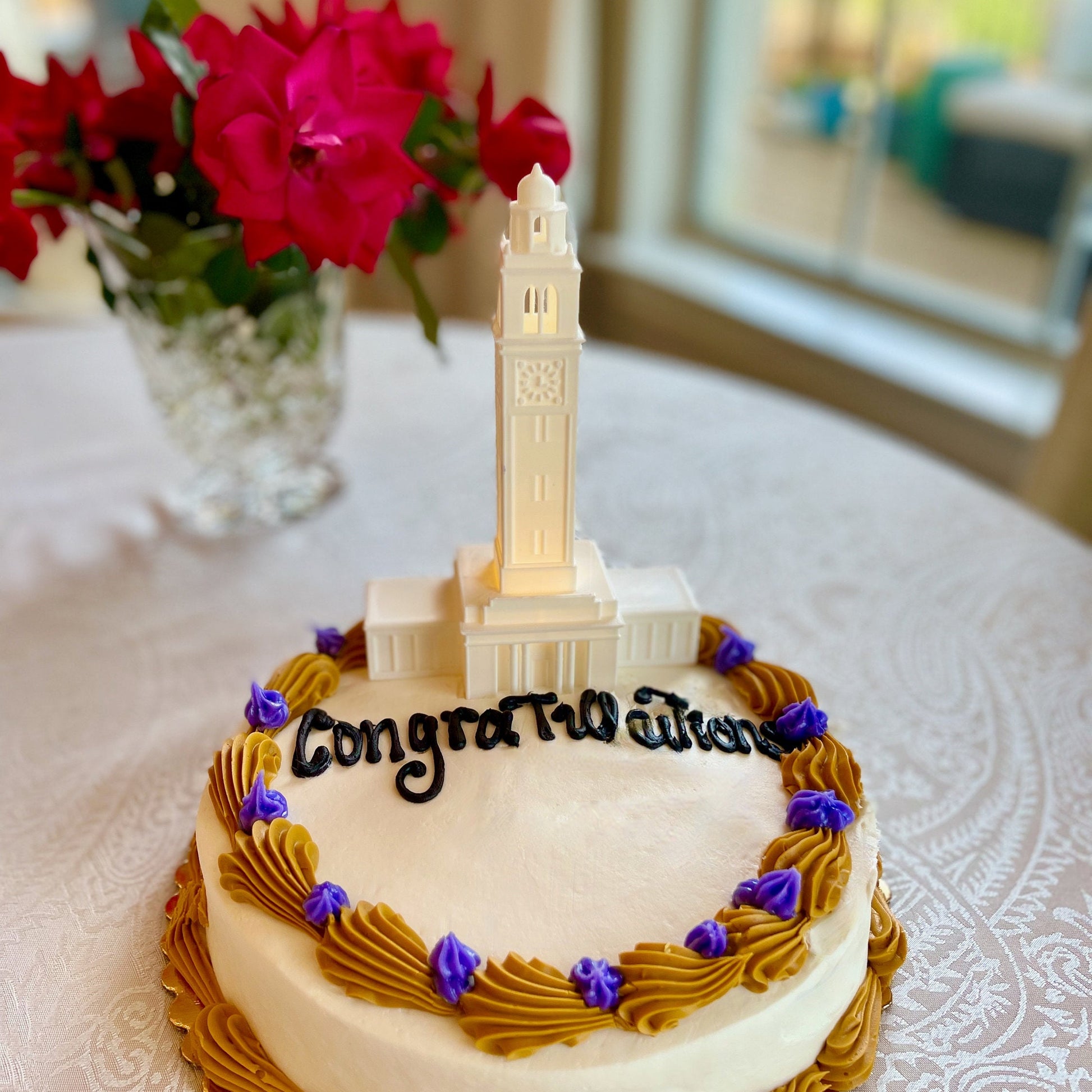 The LSU cake topper with light, designed to look like the LSU Memorial Tower and shown on an LSU graduation cake.