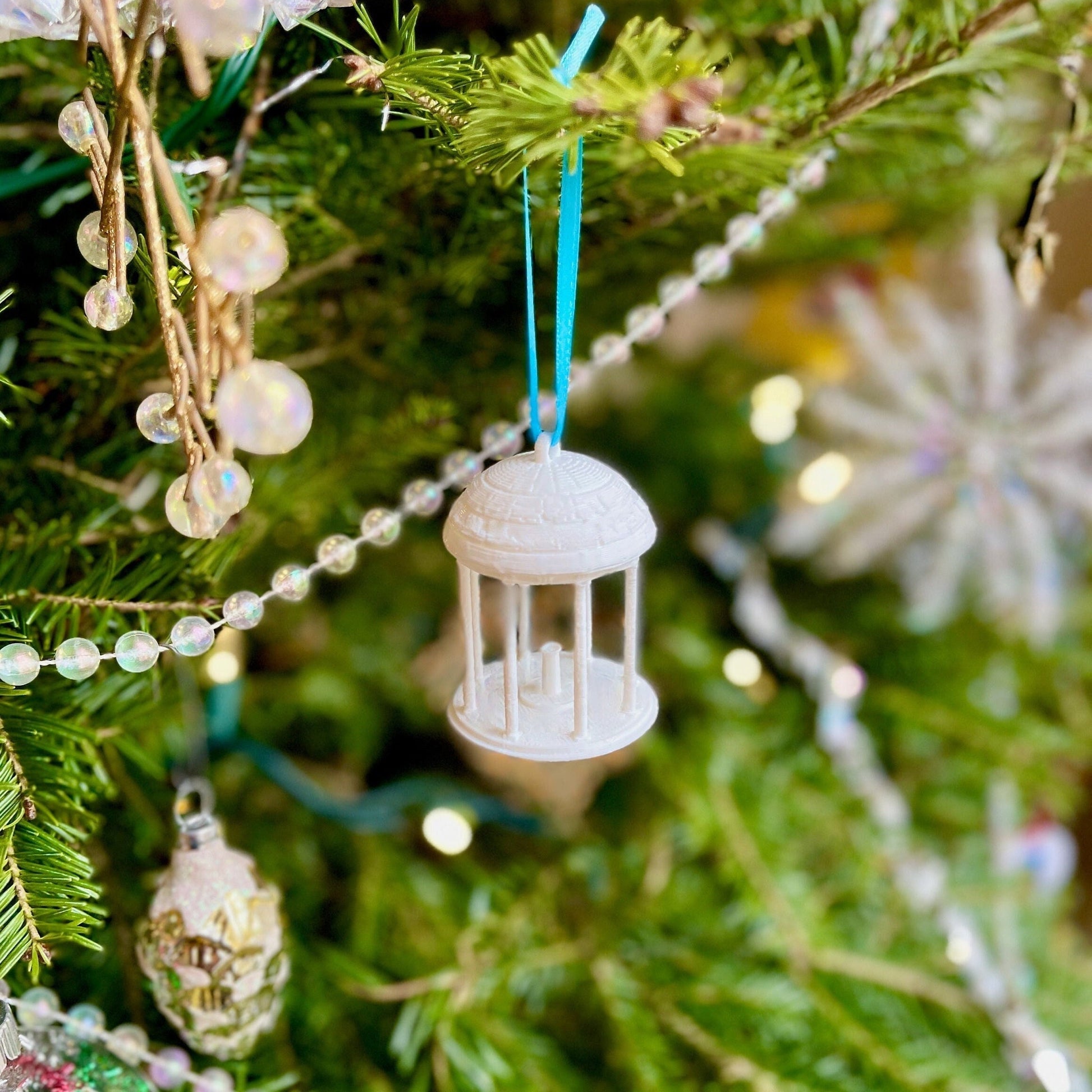 The UNC Old Well ornament, shown on a Christmas tree.