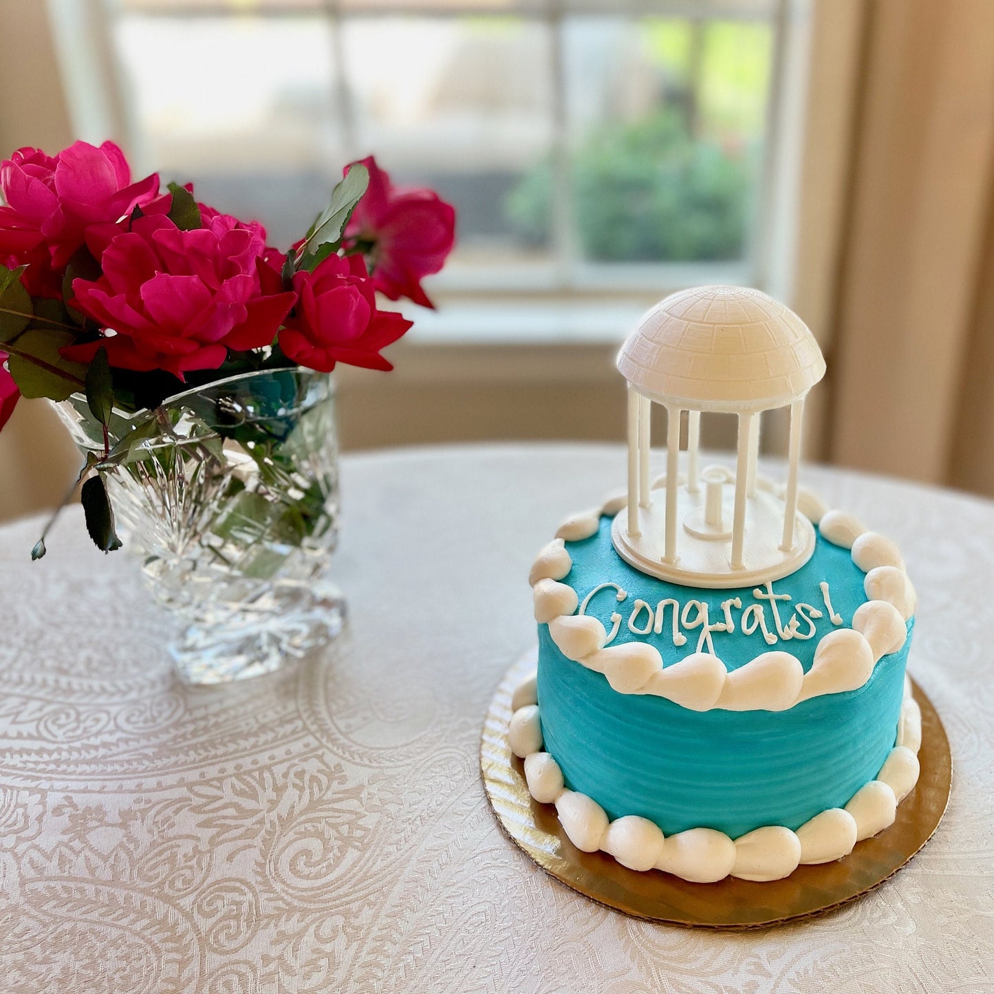 A UNC graduation cake, shown with a UNC Old Well cake topper.