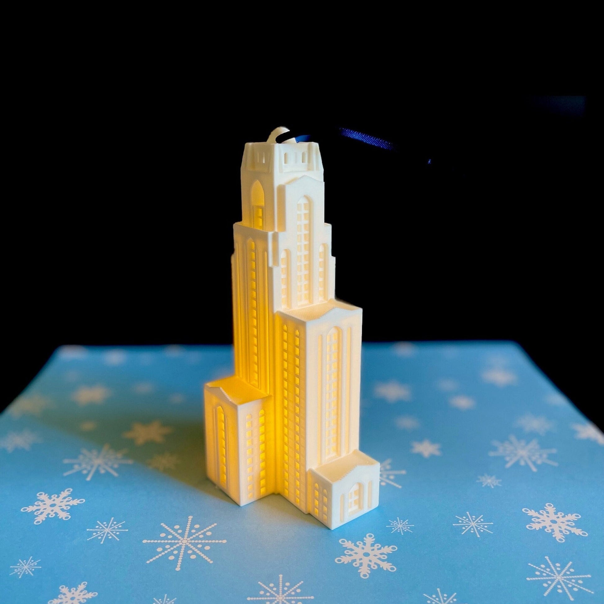 The University of Pittsburg ornament, shown against a blue background.