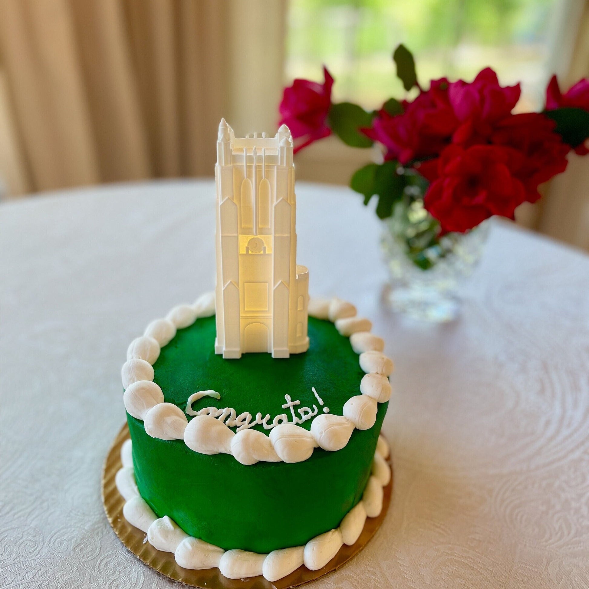 The lighted Michigan State University cake topper. shown on a graduation cake.