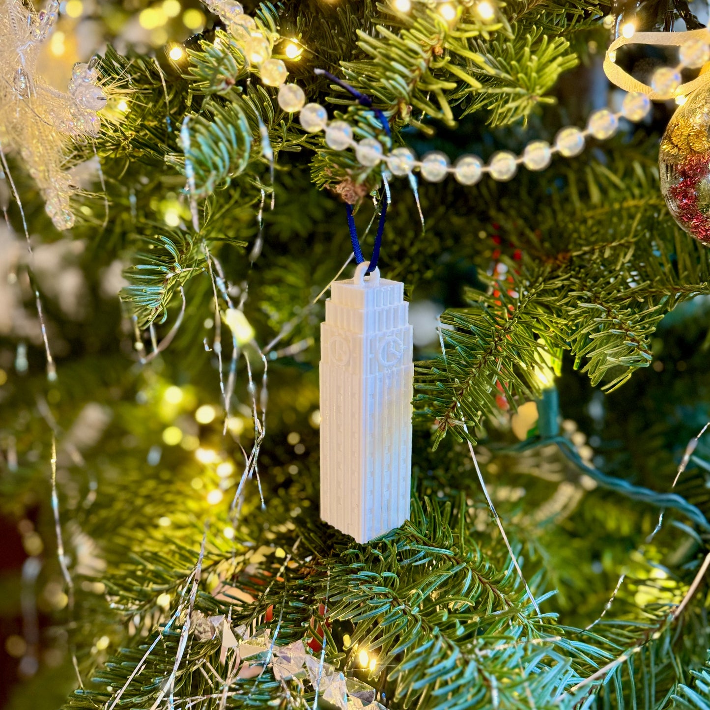 The 3D printed University of Michigan ornament, shown on a Christmas tree decorated for the holidays.