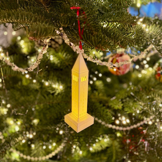 The lighted Cornell ornament, designed in honor of the McGraw Tower and shown on a Christmas tree.