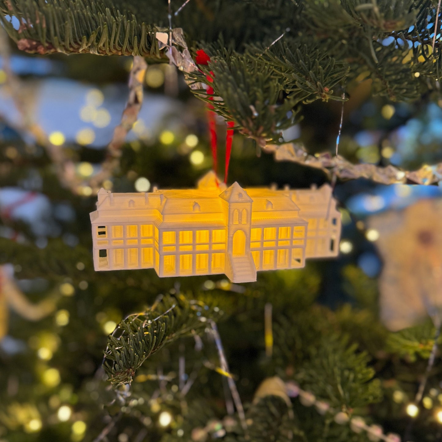 The University Arizona ornament with a light, shown on a tree decorated for the holidays.