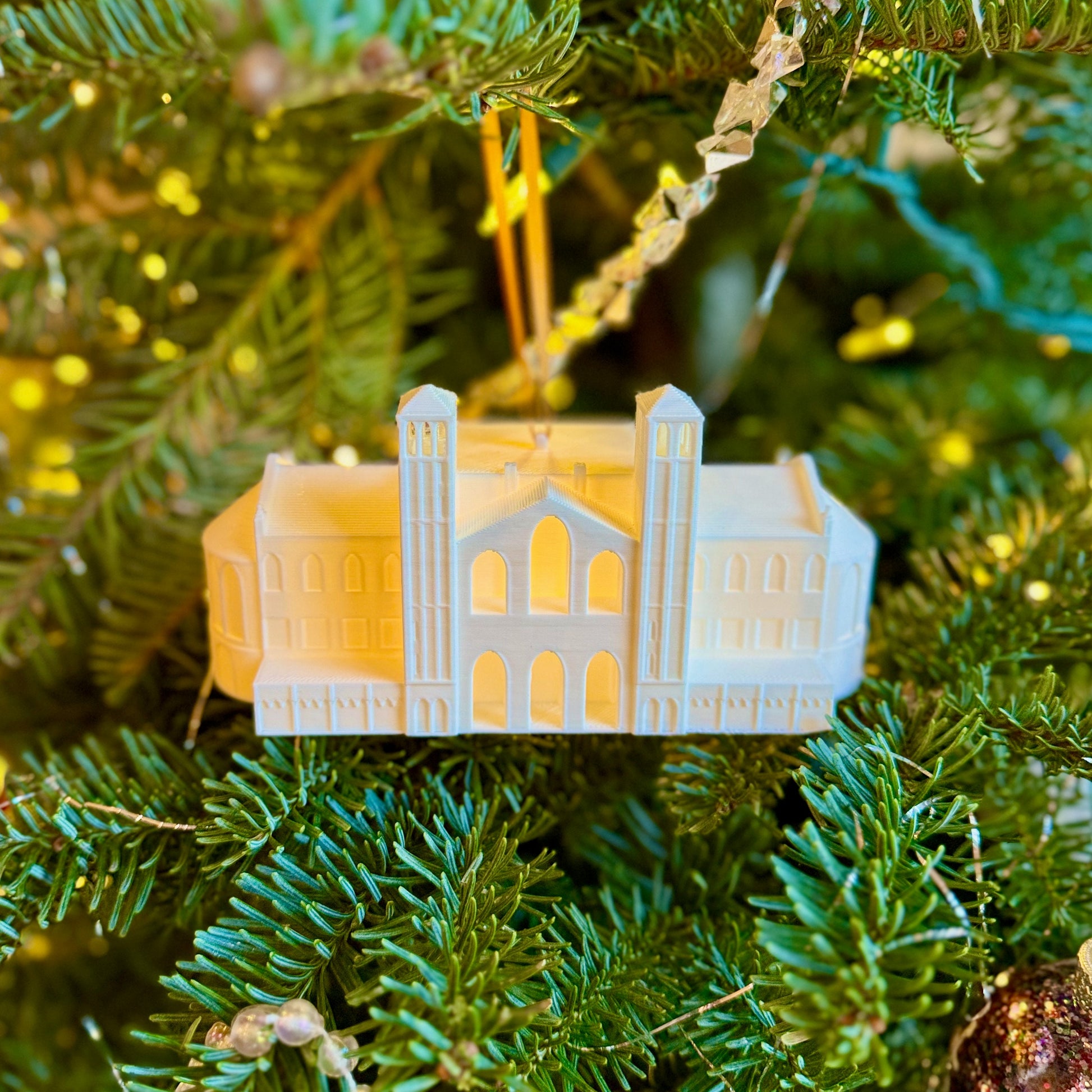 The lighted UCLA Royce Hall ornament, shown on a Christmas tree.